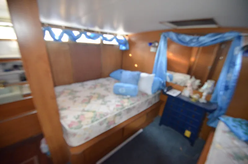 Slide: The Image of 1964 Chris-Craft Constellation cabin interior with bed, floral bedding, and blue curtains. - 16