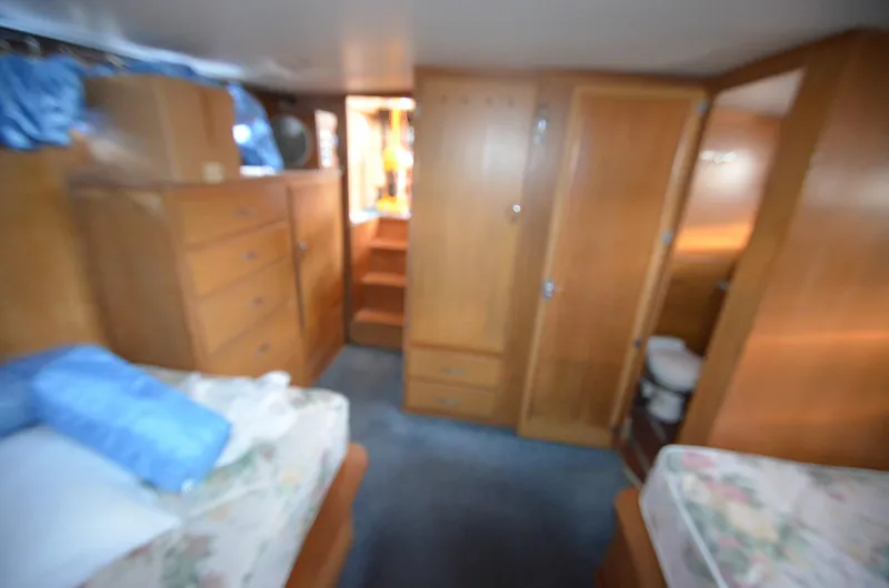 Slide: The Image of 1964 Chris-Craft Constellation cabin interior with wooden furniture and twin beds. - 18