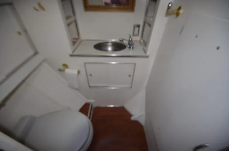 Slide: The Image of 1964 Chris-Craft Constellation boat bathroom with sink, toilet, and wooden floor. - 20