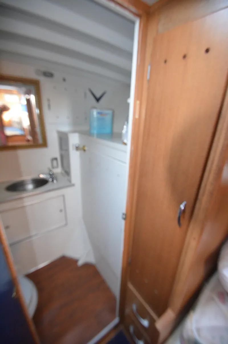 Slide: The Image of 1964 Chris-Craft Constellation yacht bathroom with sink, mirror, and wooden cabinetry. - 21