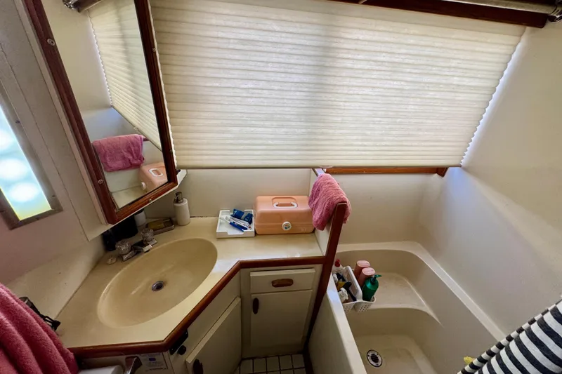 Slide: The Image of Cozy bedroom interior of 1988 Kadey-Krogen Silhouette yacht with patterned bedding. - 21