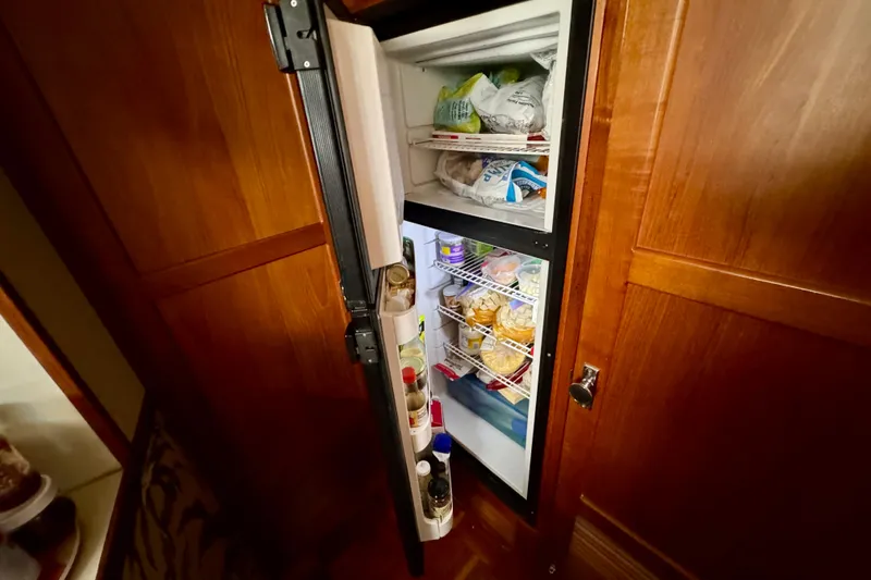 Slide: The Image of 1988 Kadey-Krogen Silhouette interior with wooden cabinetry and built-in refrigerator. - 29