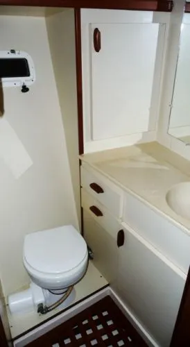 Slide: The Image of Compact bathroom in a 1988 Kadey-Krogen Silhouette yacht with sink, toilet, and toiletries. - 31