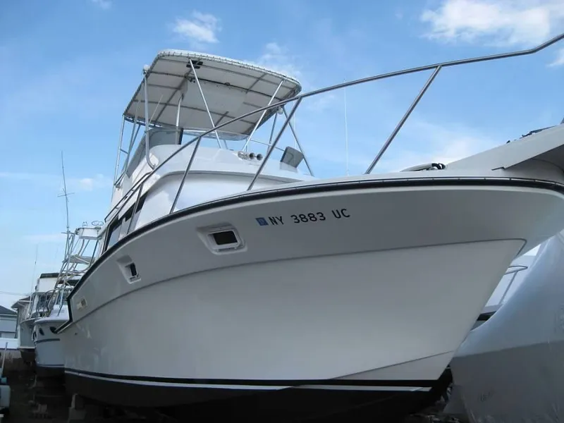 Slide: The Image of 1989 Luhrs 342 Tournament boat docked, side view under blue sky. - 8