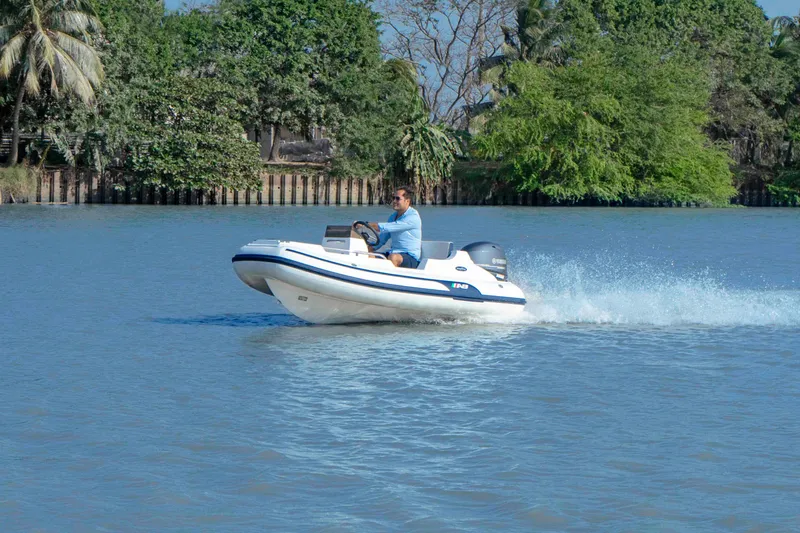 Slide: The Image of 2023 AB Inflatables 11 DLX boat cruising on a calm river. - 8