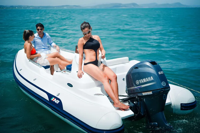 Slide: The Image of 2024 AB Inflatables 15 DLX boat with Yamaha engine on the water. - 15