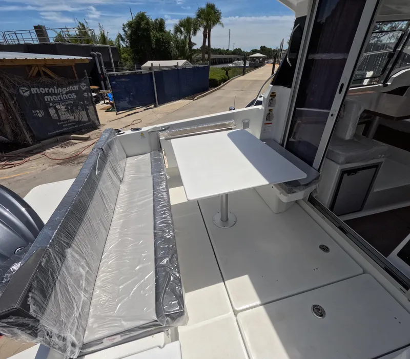 Slide: The Image of 2024 Jeanneau NC 795 boat with outdoor seating and table. - 4
