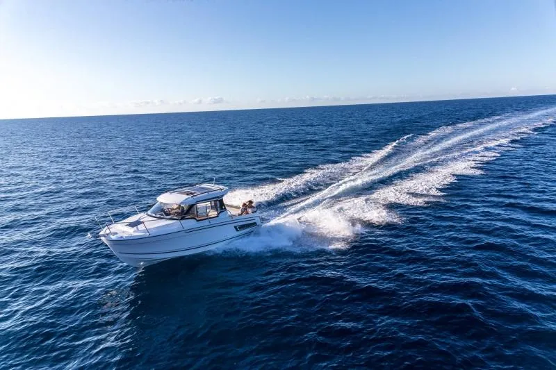 Slide: The Image of 2024 Jeanneau NC 795 motorboat cruising on open water. - 44