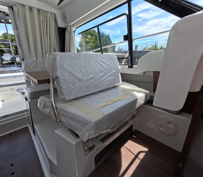 Slide: The Image of Interior of 2024 Jeanneau NC 795 boat with wrapped seating and large windows. - 5
