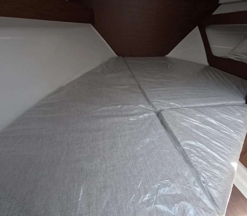 Slide: The Image of 2024 Jeanneau NC 795 cabin interior with bed and storage shelves - 6