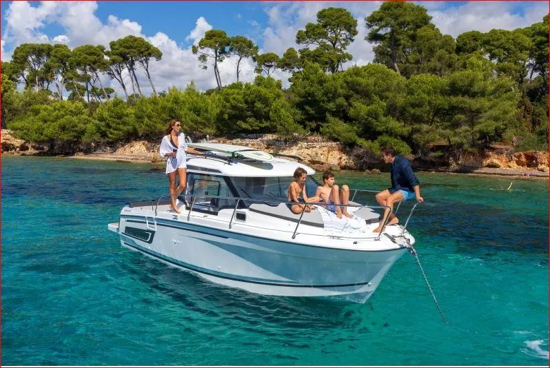 Slide: The Image of 2024 Jeanneau NC 795 boat cruising in clear blue waters with people onboard. - 9