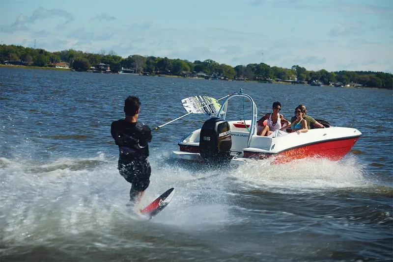 Slide: The Image of 2023 Bayliner Element E18 towing a wakeboarder on a lake. - 15