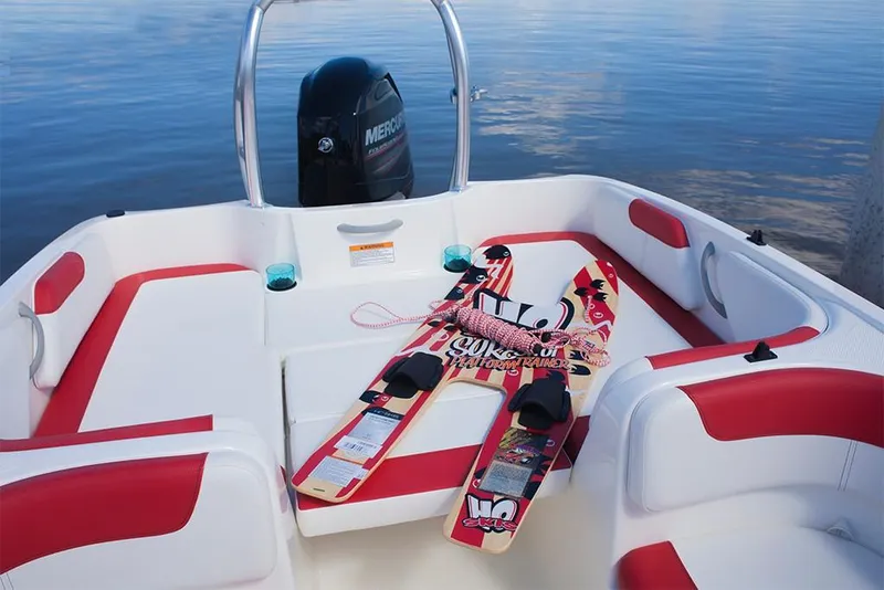 Slide: The Image of 2023 Bayliner Element E18 boat interior with water skis on red and white seats. - 17