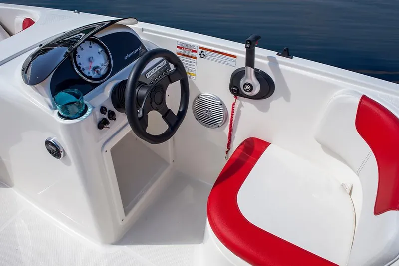 Slide: The Image of 2023 Bayliner Element E18 boat cockpit with steering wheel and red-accented seat. - 19