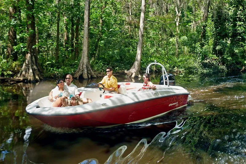 Slide: The Image of 2023 Bayliner Element E18 boat cruising on a forested river. - 30