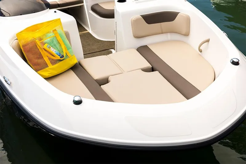 Slide: The Image of 2023 Bayliner Element E21 boat with beige seating and a yellow bag on the deck. - 19