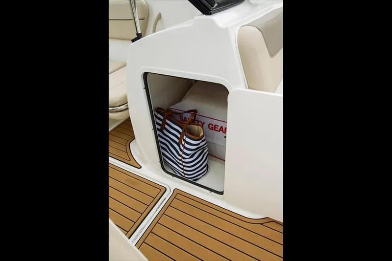 Slide: The Image of 2023 Bayliner VR5 Bowrider storage compartment with striped bag and safety gear. - 15