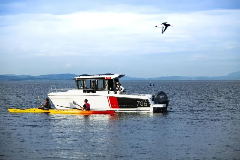 Slide: The Image of Group of friends camping by the lake with Jeanneau NC795 boat in the background. - 10