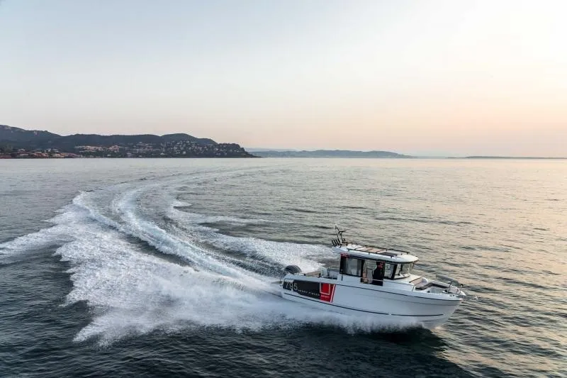 Slide: The Image of 2023 Jeanneau NC795 Sport Series 2 boat cruising on open water. - 12