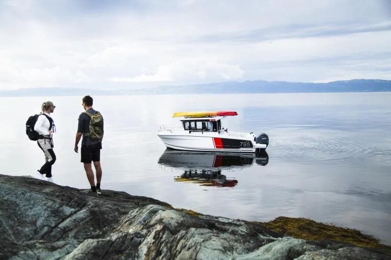 Slide: The Image of 2023 Jeanneau NC795 Sport Series 2 boat near campers on rocky shore at sunset - 23