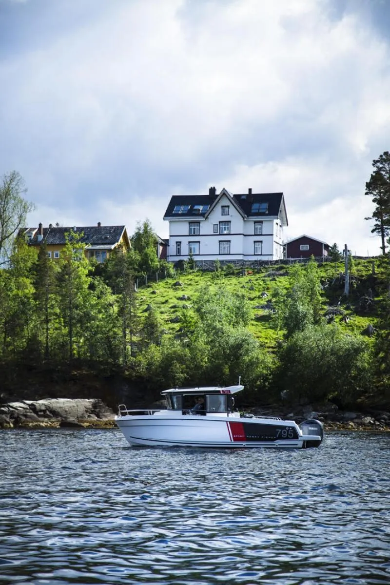 Slide: The Image of 2023 Jeanneau NC795 Sport Series 2 boat with a windsurfer in action. - 9