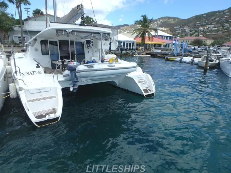 Slide: The Image of 2015 Fountaine Pajot MAHE EVO catamaran docked in harbor, surrounded by water and boats. - 5