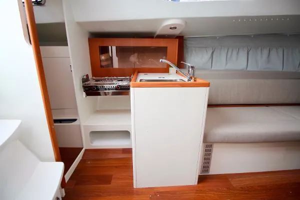 Slide: The Image of 2024 J Boats J/99 interior with compact kitchen, sink, and seating area. - 12