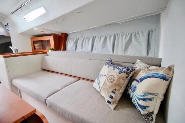 Slide: The Image of 2024 J Boats J/99 interior with cozy seating and decorative pillows. - 13