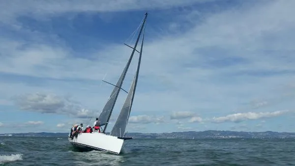 Slide: The Image of 2024 J Boats J/99 sailing on open water under a clear sky. - 4