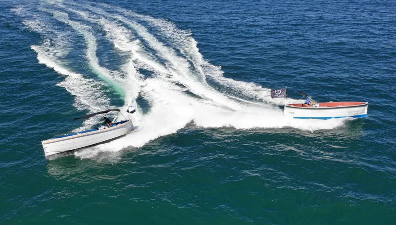 Slide: The Image of Two Lekker Damsko 750 boats speeding on open water, creating dynamic wake patterns. - 3