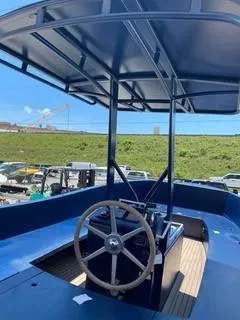 Slide: The Image of 2018 Lekker Damsko 750 Open boat with steering wheel and canopy, docked outdoors. - 7