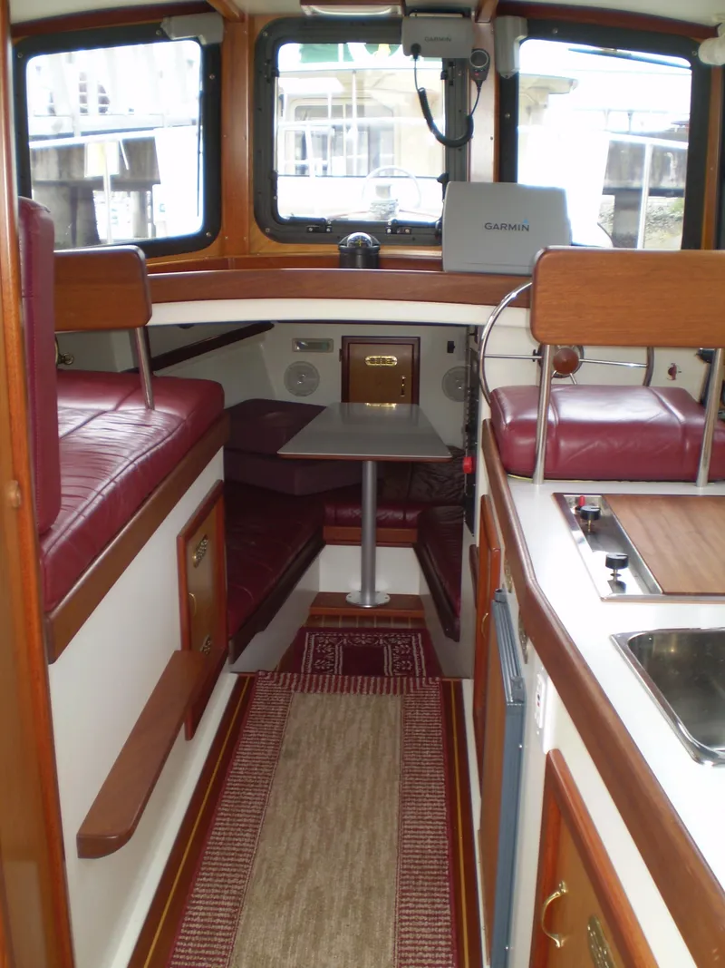Slide: The Image of Interior of 2000 Devlin Surf Scoter boat with red seating and wooden accents. - 10