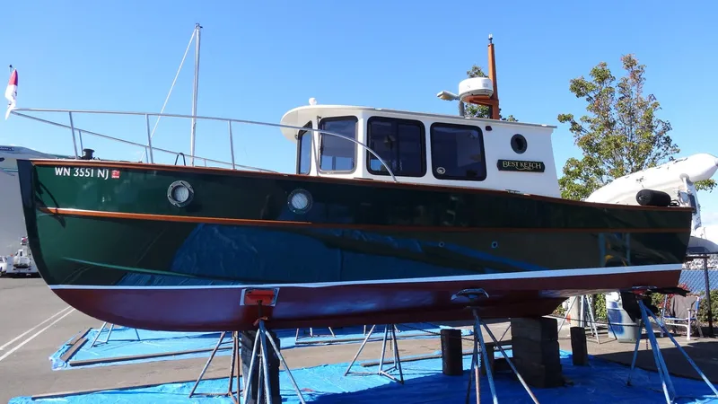 Slide: The Image of 2000 Devlin Surf Scoter boat on stands, green hull, docked outdoors. - 2