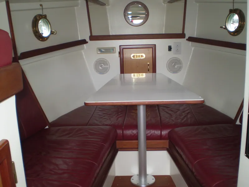 Slide: The Image of Interior of 2000 Devlin Surf Scoter boat with red seating and white table. - 32