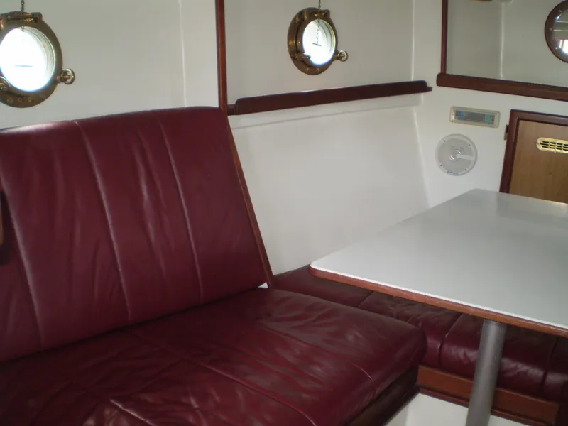 Slide: The Image of Interior of 2000 Devlin Surf Scoter boat with burgundy seating and white table. - 34