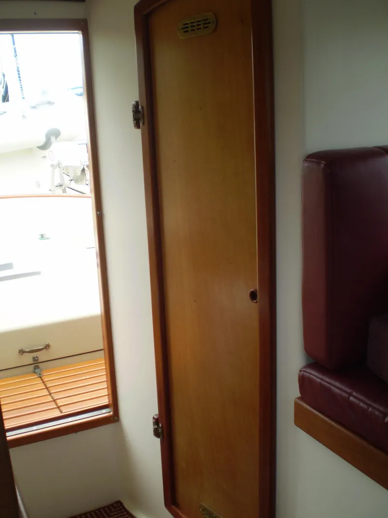 Slide: The Image of Interior view of a 2000 Devlin Surf Scoter boat, featuring a wooden door and seating. - 35