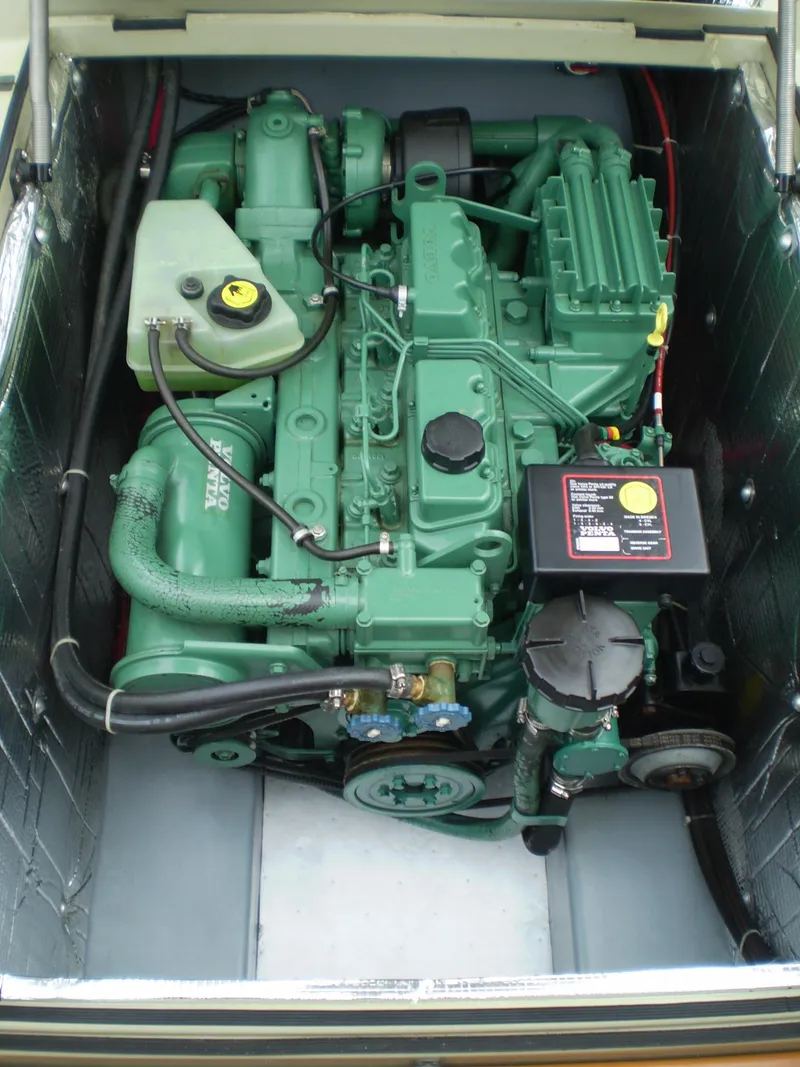 Slide: The Image of Engine compartment of a 2000 Devlin Surf Scoter boat, featuring a green marine engine. - 42