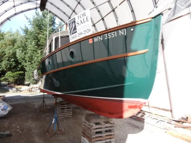 Slide: The Image of Devlin Surf Scoter 2000 boat for sale, green hull, displayed in covered area. - 47