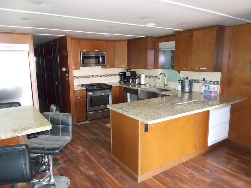 Slide: The Image of Modern kitchen in 2013 Bravada Tranquility Trip 17 houseboat with granite countertops and wood cabinets. - 3
