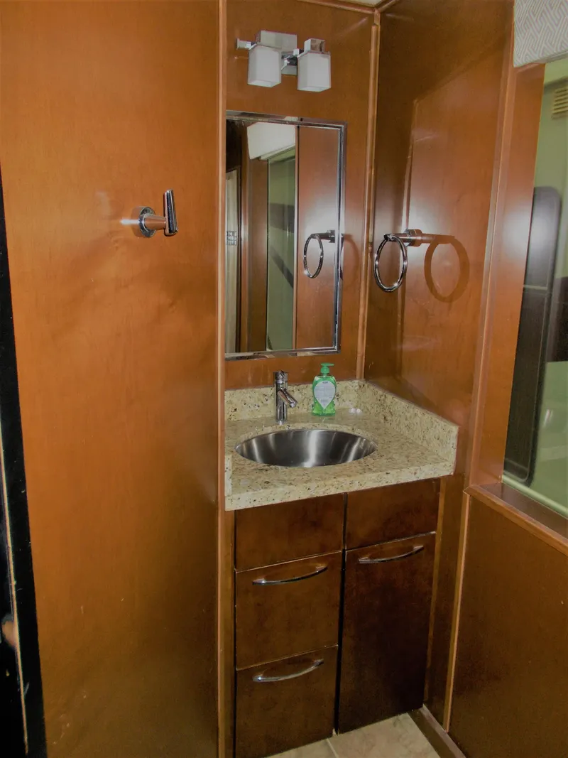 Slide: The Image of 2013 Bravada Tranquility Trip 17 bathroom with wood cabinetry and stainless steel sink. - 5