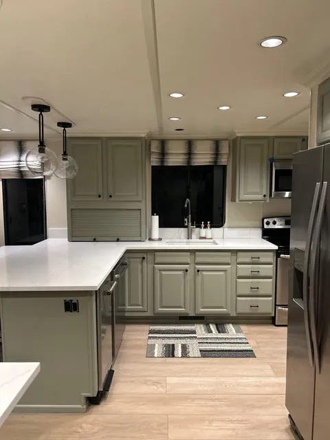 Slide: The Image of Modern kitchen in a 2008 Sumerset Red Rocks Trip 11 houseboat with green cabinets and stainless steel appliances. - 24