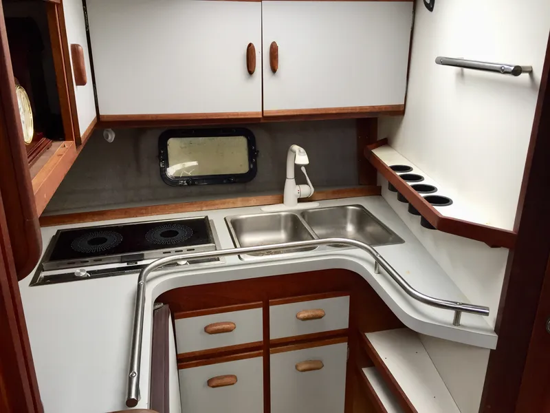 Slide: The Image of 1986 Cruisers Yachts 336 Ultra Vee galley with stove, sink, and storage cabinets. - 10