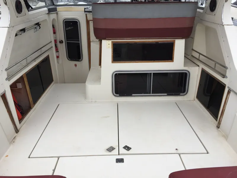 Slide: The Image of 1986 Cruisers Yachts 336 Ultra Vee interior with white deck and maroon accents. - 2