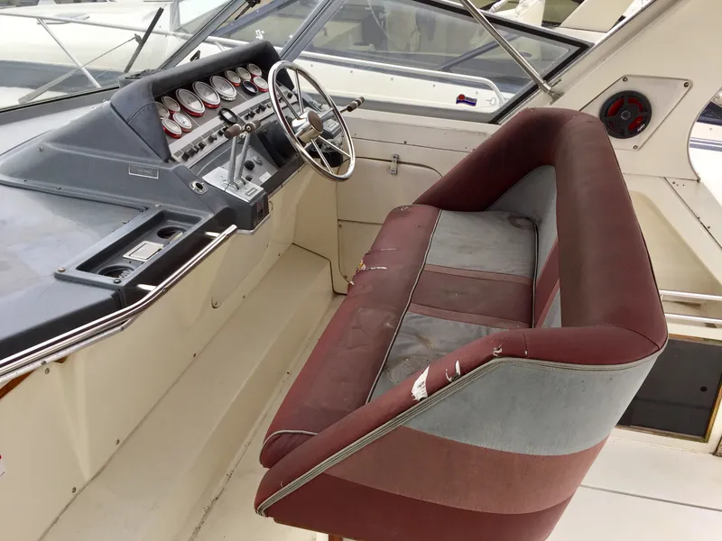 Slide: The Image of 1986 Cruisers Yachts 336 Ultra Vee cockpit with vintage dashboard and worn seating. - 4