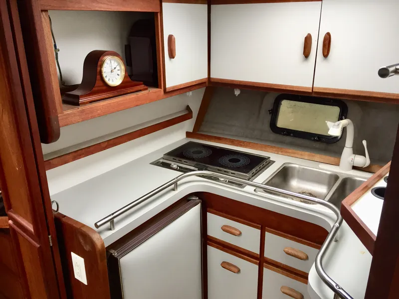 Slide: The Image of 1986 Cruisers Yachts 336 Ultra Vee kitchen with stove, sink, and wooden cabinets. - 9