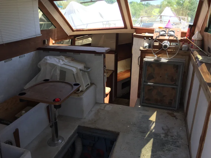 Slide: The Image of 1980 Trojan F-30 Flybridge Sedan interior with steering wheel, windows, and seating area. - 4