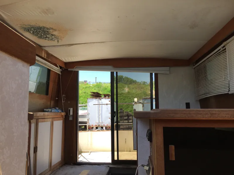 Slide: The Image of Interior view of 1980 Trojan F-30 Flybridge Sedan with sliding glass door and wooden cabinetry. - 5