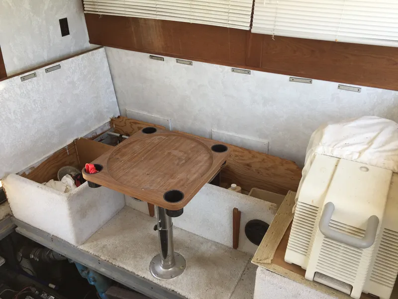 Slide: The Image of Interior of 1980 Trojan F-30 Flybridge Sedan with wooden table and storage compartments. - 6