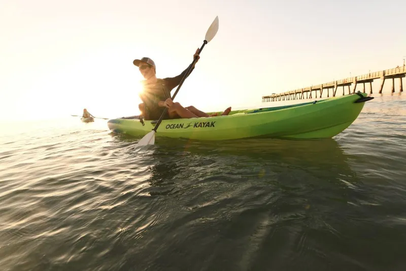 Slide: The Image of Person kayaking on Ocean Kayak Malibu 11.5 at sunset near a pier. - 12