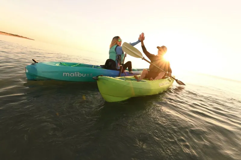 Slide: The Image of Two people kayaking on Ocean Kayak Malibu 11.5 at sunset, 2023 model. - 2